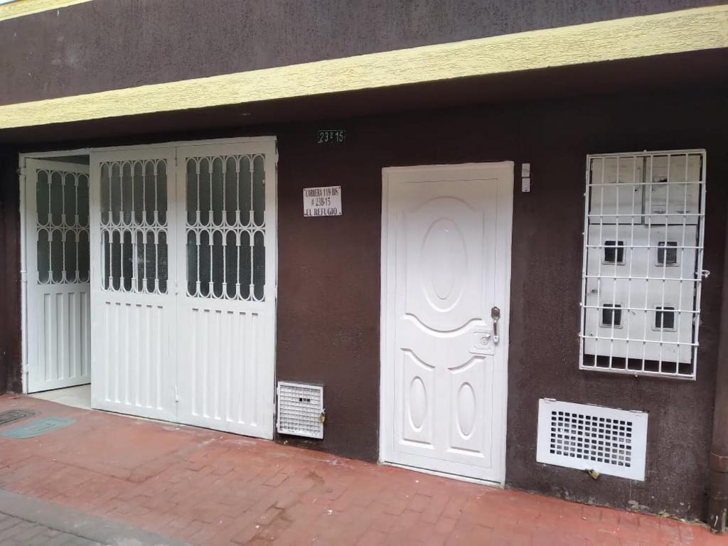 un edificio con tres puertas y ventanas blancas en El descanso, en Bogotá