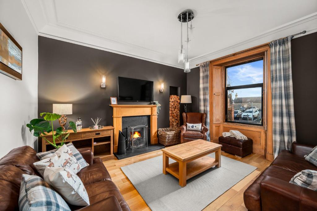 a living room with a couch and a fireplace at Fontain House: 4 bedroom Victorian villa in Blairgowrie