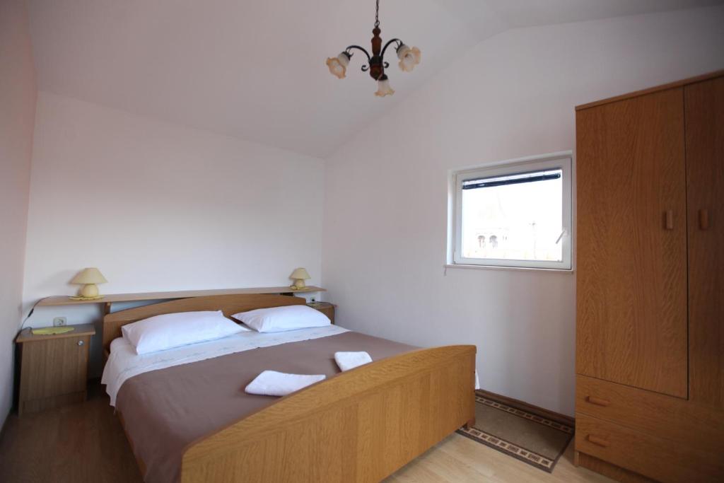 1 dormitorio con 1 cama con 2 almohadas y ventana en Apartment Jure, en Trogir