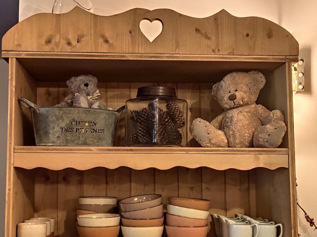 two teddy bears sitting on a shelf with dishes at Les Chemins du Léman in Novel