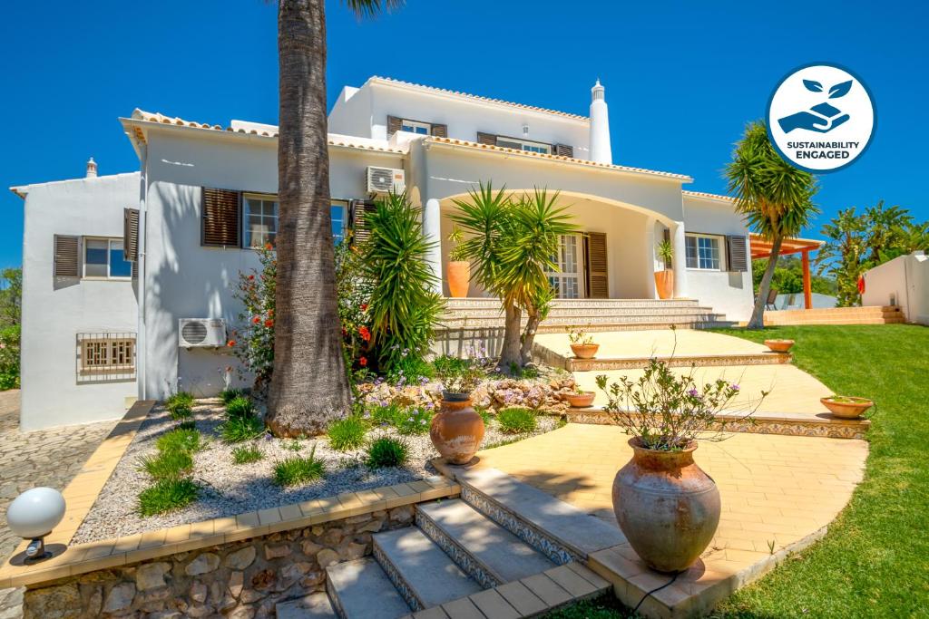 una casa con una palmera delante de ella en Villa Valentina by Algarve Vacation, en Almancil
