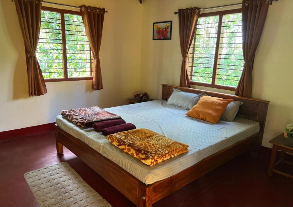 un letto in una camera con due finestre di The Wind Chime - SUPRAD Estate a Suntikoppa