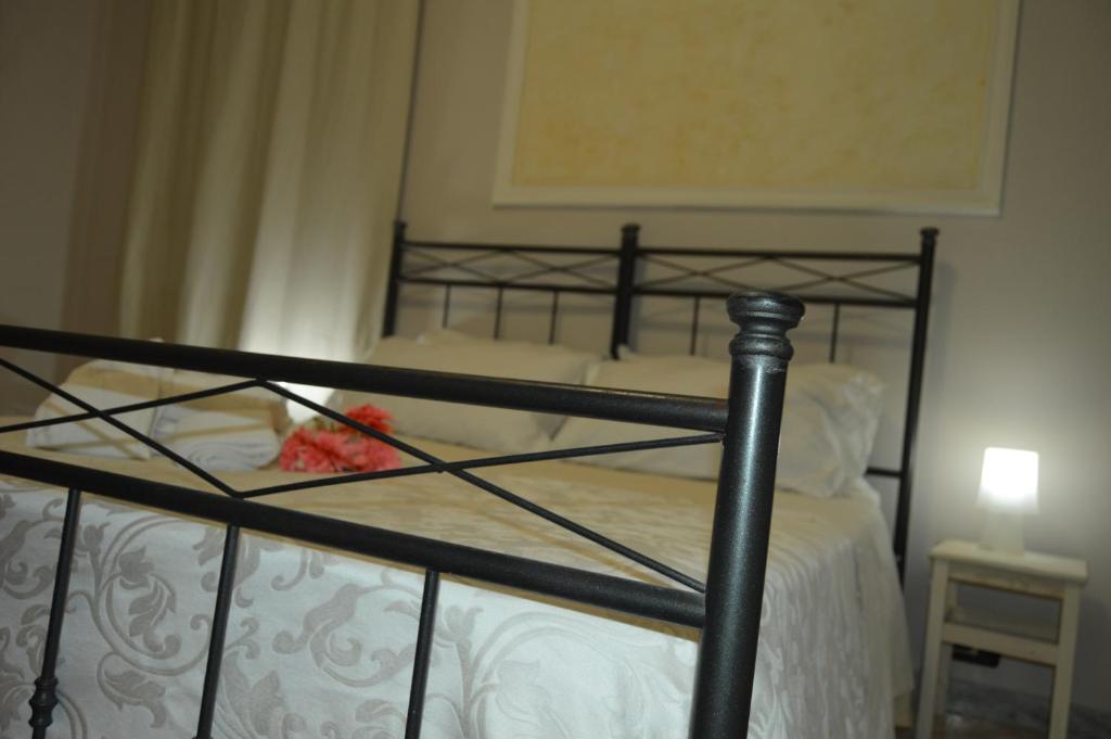 Litera de metal negro con sábanas blancas y lámpara en Bed and Breakfast Vecchio Porto en Catania
