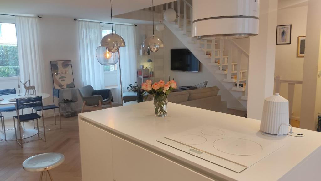 een keuken en een woonkamer met een vaas met bloemen op een toonbank bij à 50 m des plages, proche du vieux port et hypercentre superbe 3 P moderne in Cannes