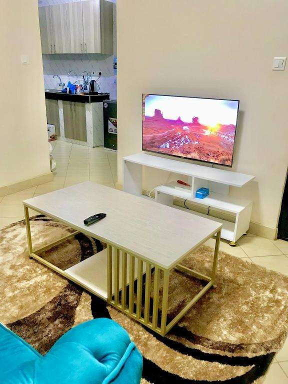 sala de estar con mesa de centro y TV en VICTOR'S SERENE STAYS, en Nairobi