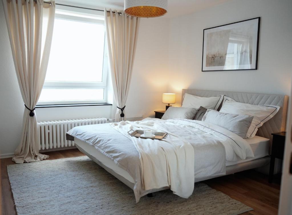 a bedroom with a large white bed with a window at Elegantes & Modernes Messe Apartment, Hannover, Laatzen in Hannover