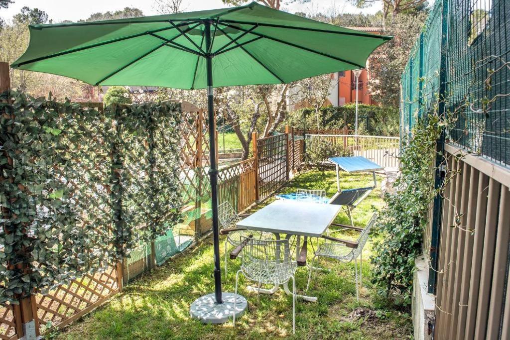 a table and chairs with a green umbrella in the yard at Bilocale con portico a Numana - N175 in Numana