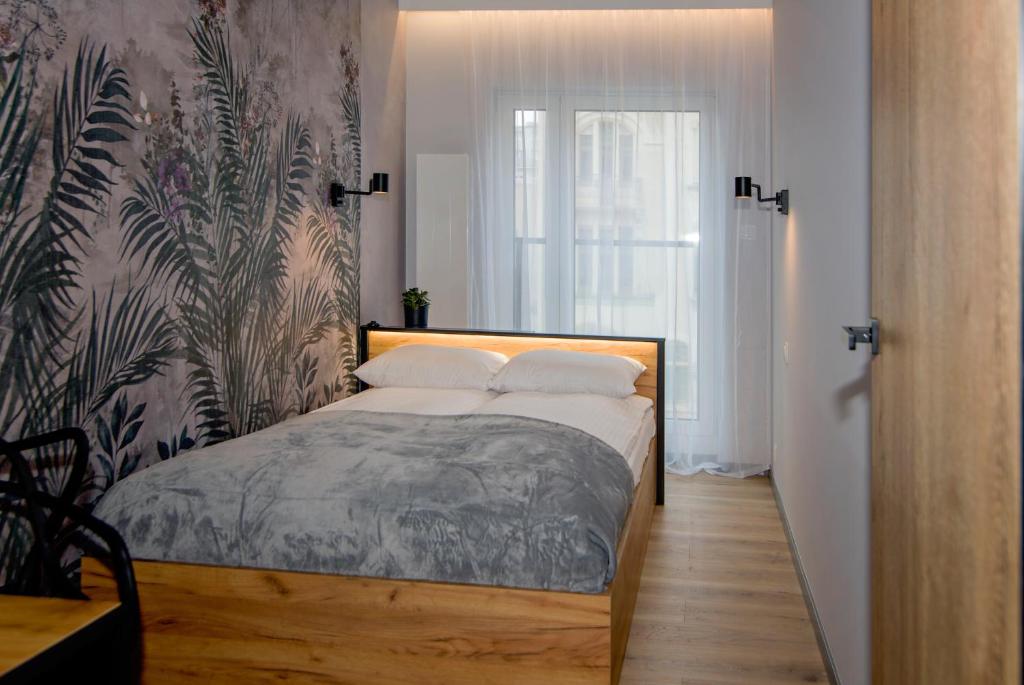 a bedroom with a bed with a wall at MTP/ZOO Prestige Apartments in Poznań