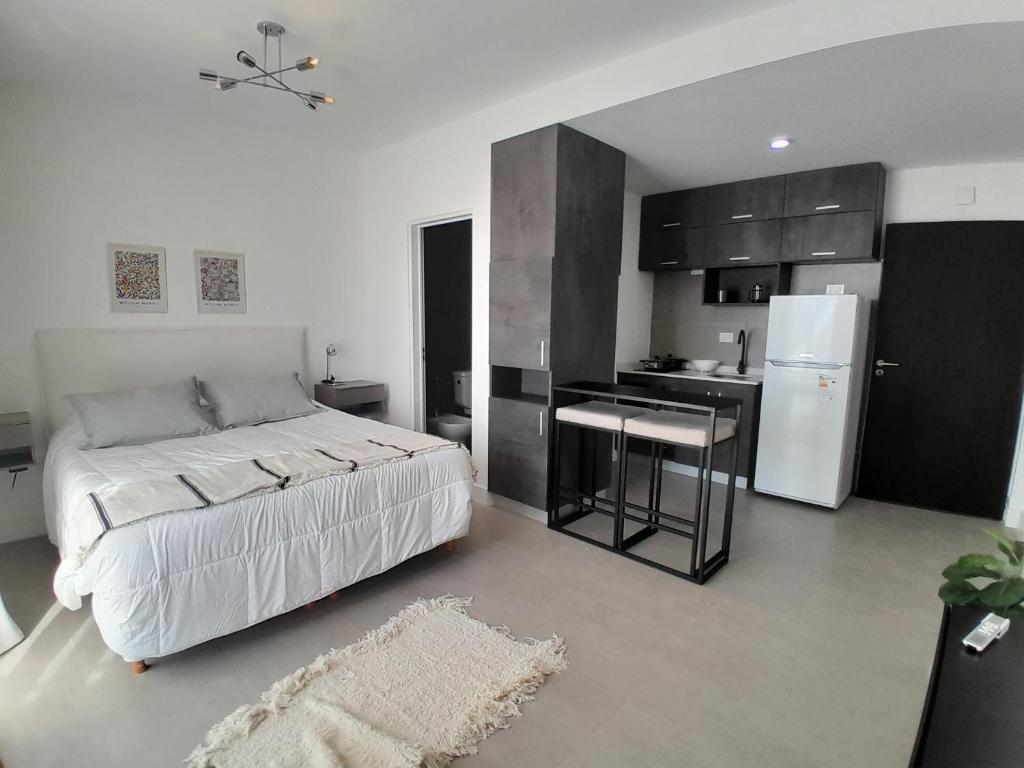 1 dormitorio con 1 cama y cocina con nevera en Elegancia y Confort G&A Rent (308) en Ezeiza