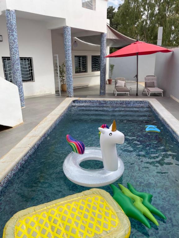 uma piscina com um unicórnio flutuante na água em Villa Kayus - Toubab Dialaw em Rufisque