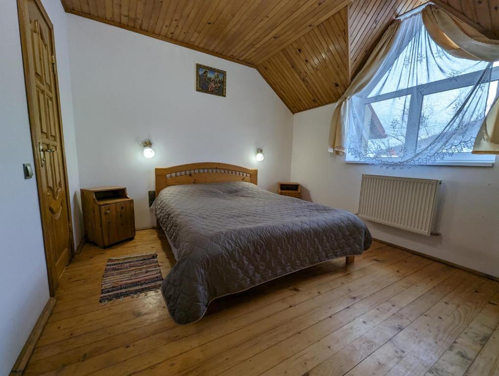 - une chambre avec un lit et une grande fenêtre dans l'établissement Oskolok Dovbusha Mini-Hotel, à Yaremtche