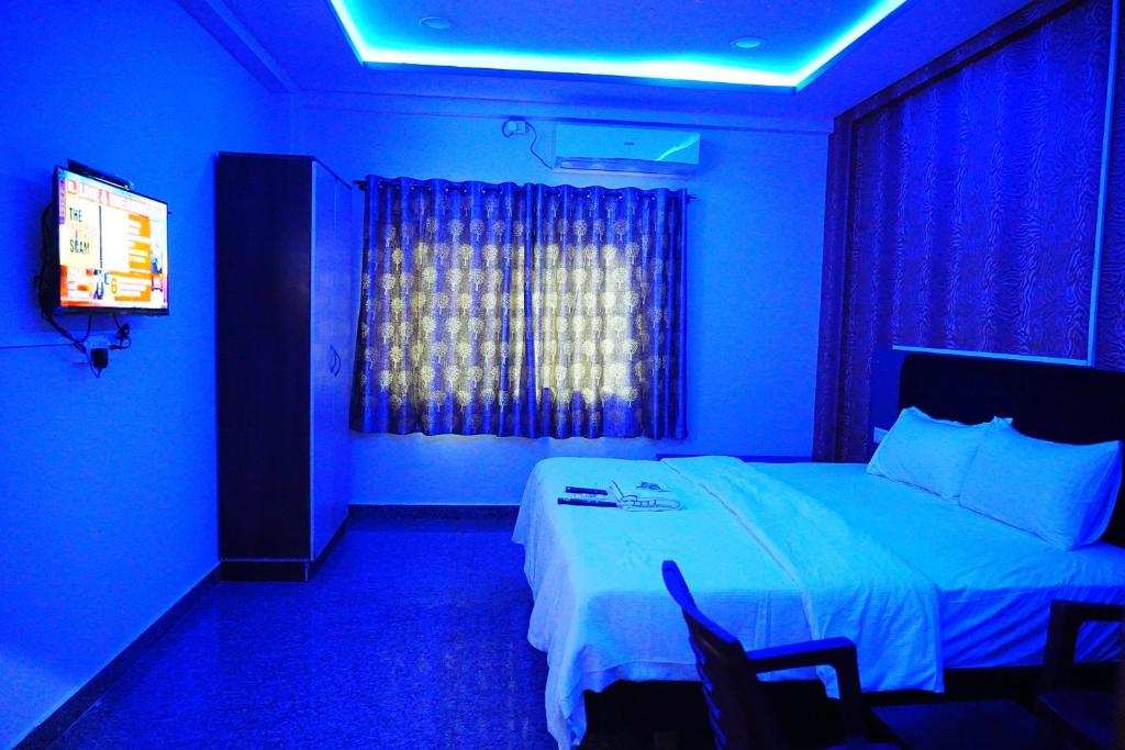 Dieses blaue Zimmer verfügt über ein Bett und einen TV. in der Unterkunft LEE PARADISE INN in Bangalore