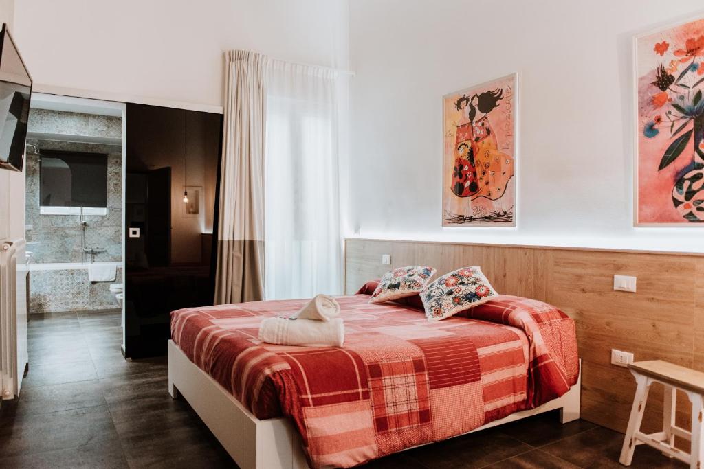 um quarto com uma cama com um cobertor xadrez vermelho em Terrae Hydrunti em Lecce