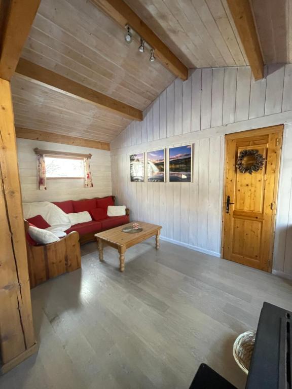 un salon avec un canapé rouge et une table dans l'établissement Les Cachettes du Hérisson - Le Choupisson, à Le Frasnois