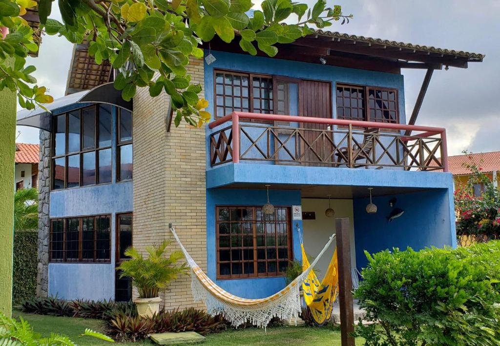 una casa azul con una hamaca delante en Chalé Azul en Tamandaré