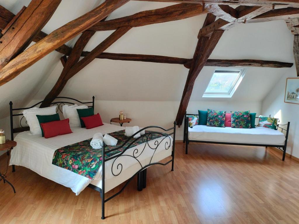 a bedroom with two beds in a room with wooden ceilings at Moulin De Bacchus - Châteaux de la Loire in Chançay