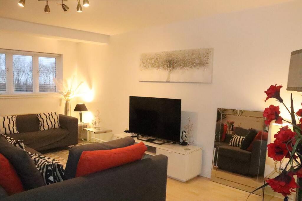 a living room with a couch and a flat screen tv at Snug 2BR Apt. Free Parking, 4KTV in London