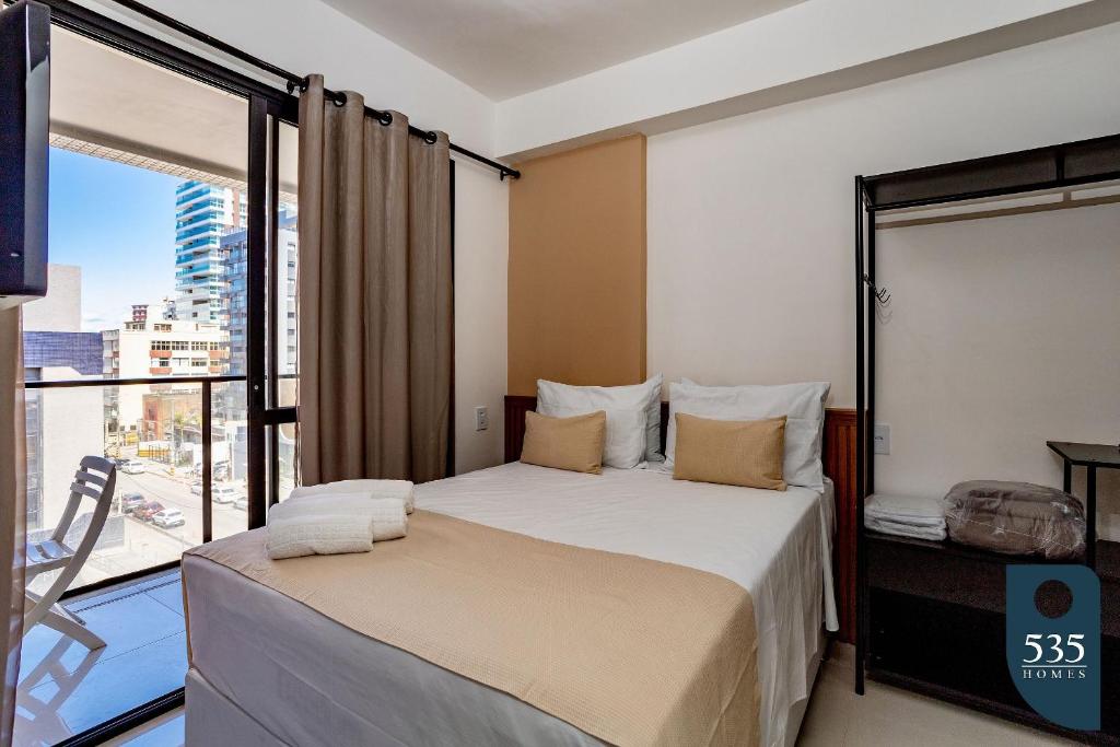 - une chambre avec un lit et une grande fenêtre dans l'établissement Mar & Conforto: Seu lar em Salvador, à Salvador