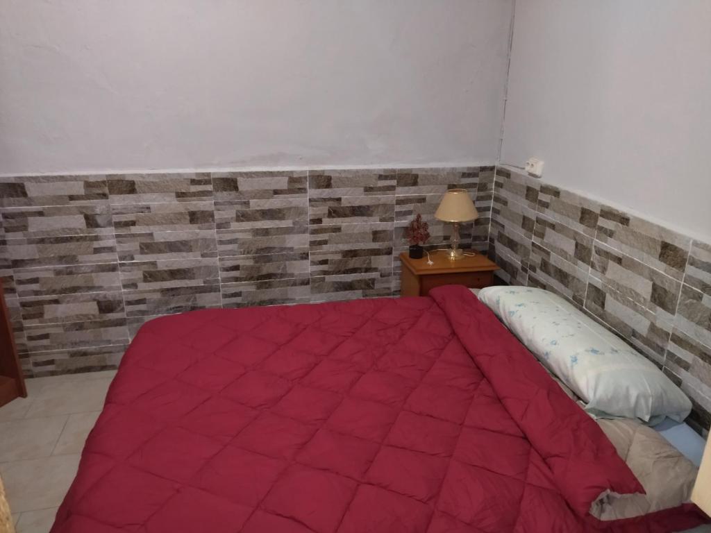 a bedroom with a bed with a red blanket at Habitación natural rústica in Cartagena