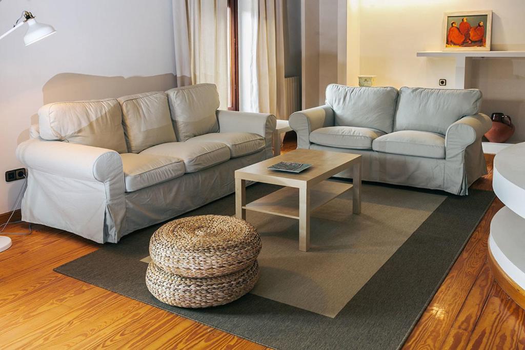 ein Wohnzimmer mit 2 Sofas und einem Couchtisch in der Unterkunft Apartamento Turistico la Solana in Baños de Río Tobía