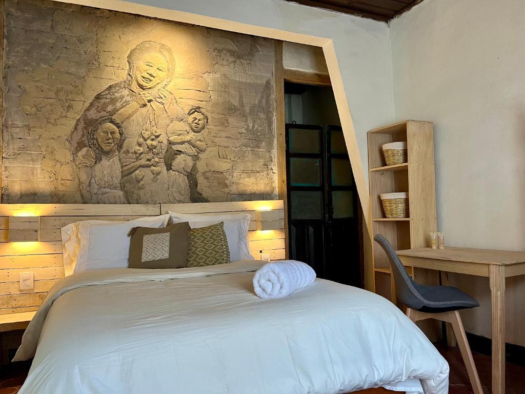 Un dormitorio con una cama con un cuadro en la pared. en Casa Cheleb, en San Cristóbal de Las Casas