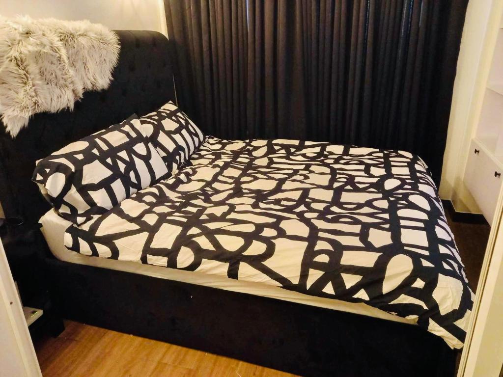 - un lit avec une couette et des oreillers en noir et blanc dans l'établissement Rm’s Inn, à Manille