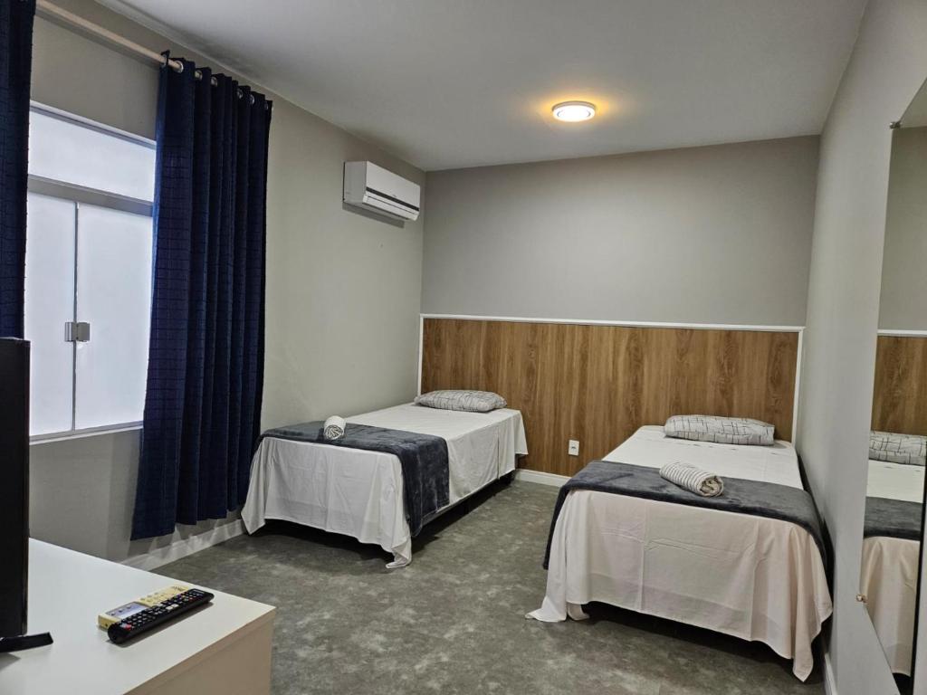 um quarto de hospital com duas camas e uma janela em Residenz100 em Blumenau