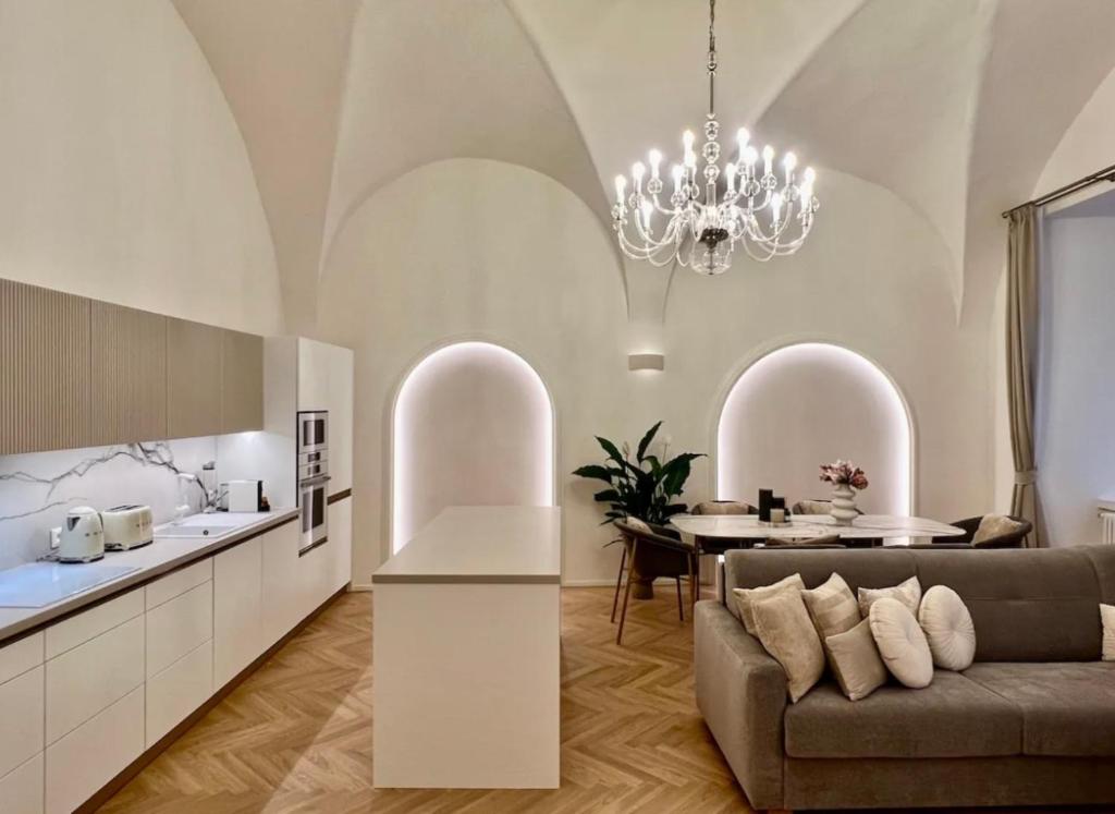 uma cozinha e sala de estar com um sofá e uma mesa em Exclusive Apartment in Praga em Praga