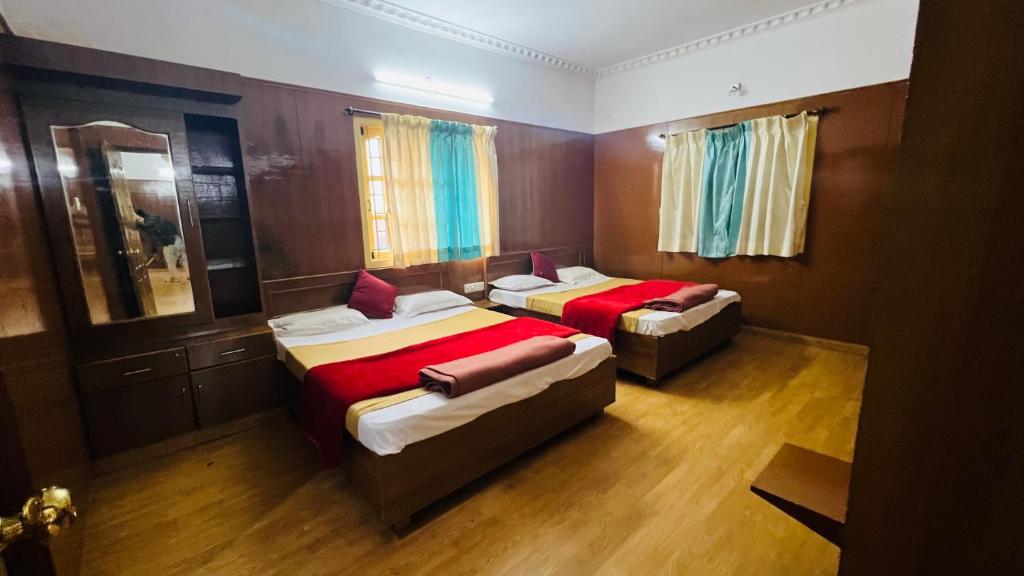 ein Schlafzimmer mit zwei Betten und einem Spiegel in der Unterkunft Hidden Valley in Udagamandalam