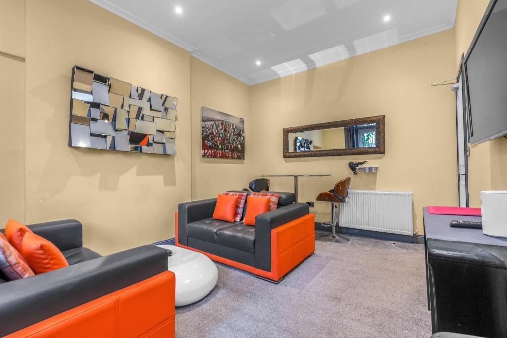 a living room with orange and black furniture at Cosy modern city centre flat in Edinburgh