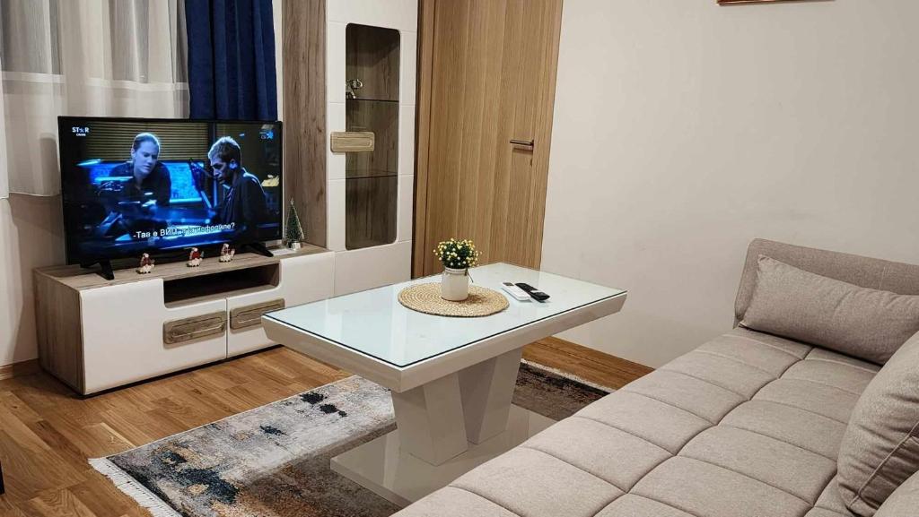 ein Wohnzimmer mit einem Sofa und einem TV in der Unterkunft Apartman Rubikon in Kumanovo