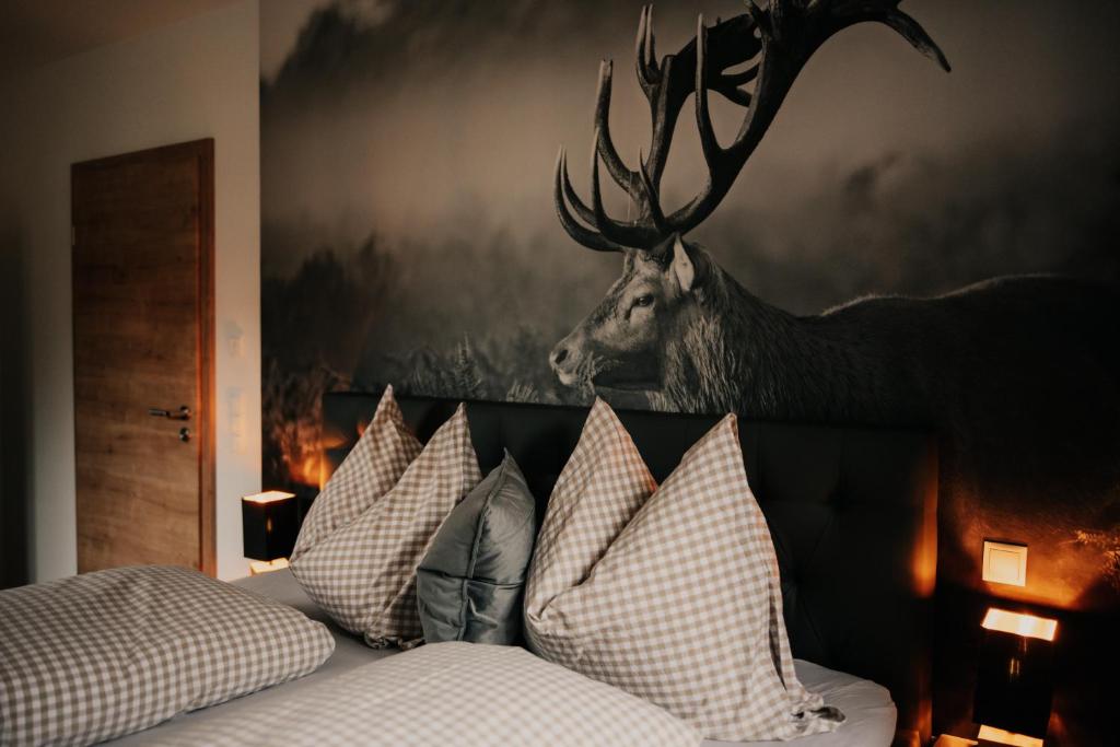 a bedroom with a bed with a deer head on the wall at Wohnung Finstermünz in Lenggries