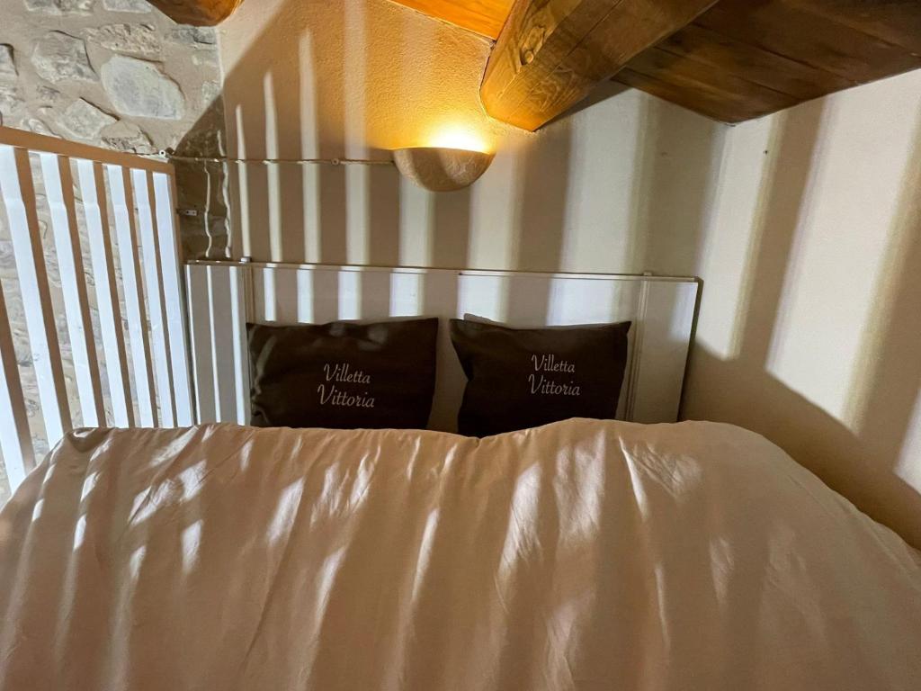 a bed with two pillows on it in a bedroom at Villetta Vittoria -Country House-Il fienile in Pennabilli