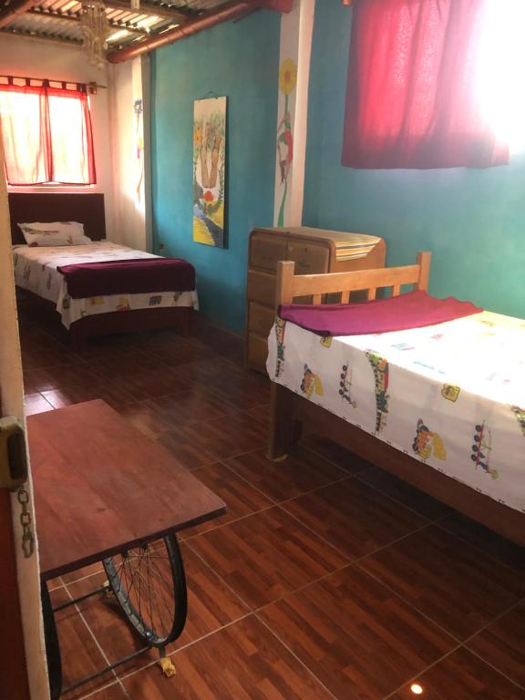 Zimmer mit 3 Betten und Holzboden in der Unterkunft LA CASA DE YOLA in Máncora