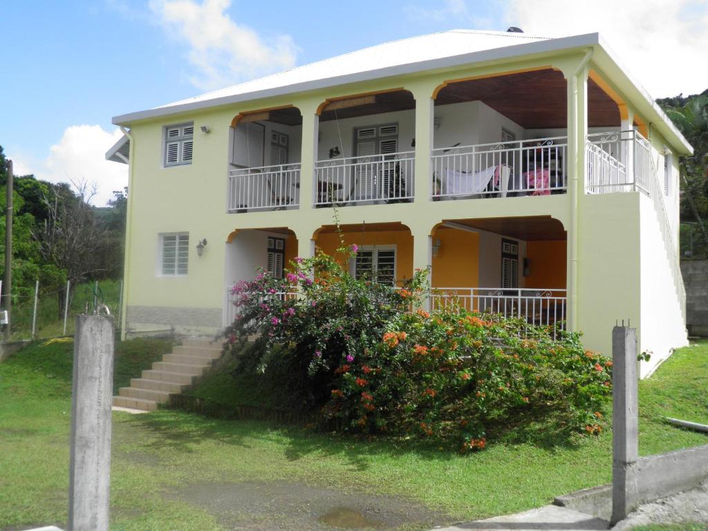 Casa blanca con balcón y flores en L'arlesienne, en Rivière-Pilote