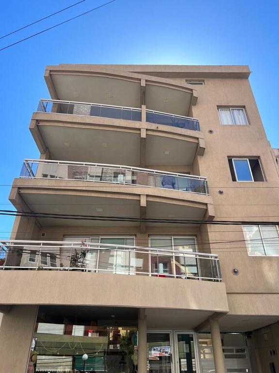 un edificio alto con un balcón en el lateral. en Apartamento Roma en Mar de Ajó