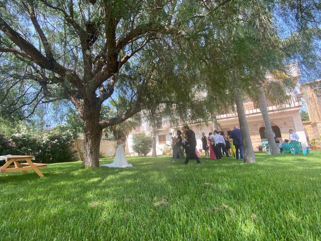 a group of people standing in the grass under a tree at Villa Piruzzu CV Torre Mulinazzo app P in Cinisi