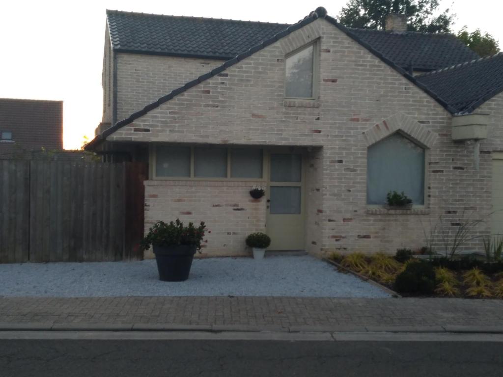 uma casa de tijolos com uma entrada em frente em Toezens em Ingelmunster