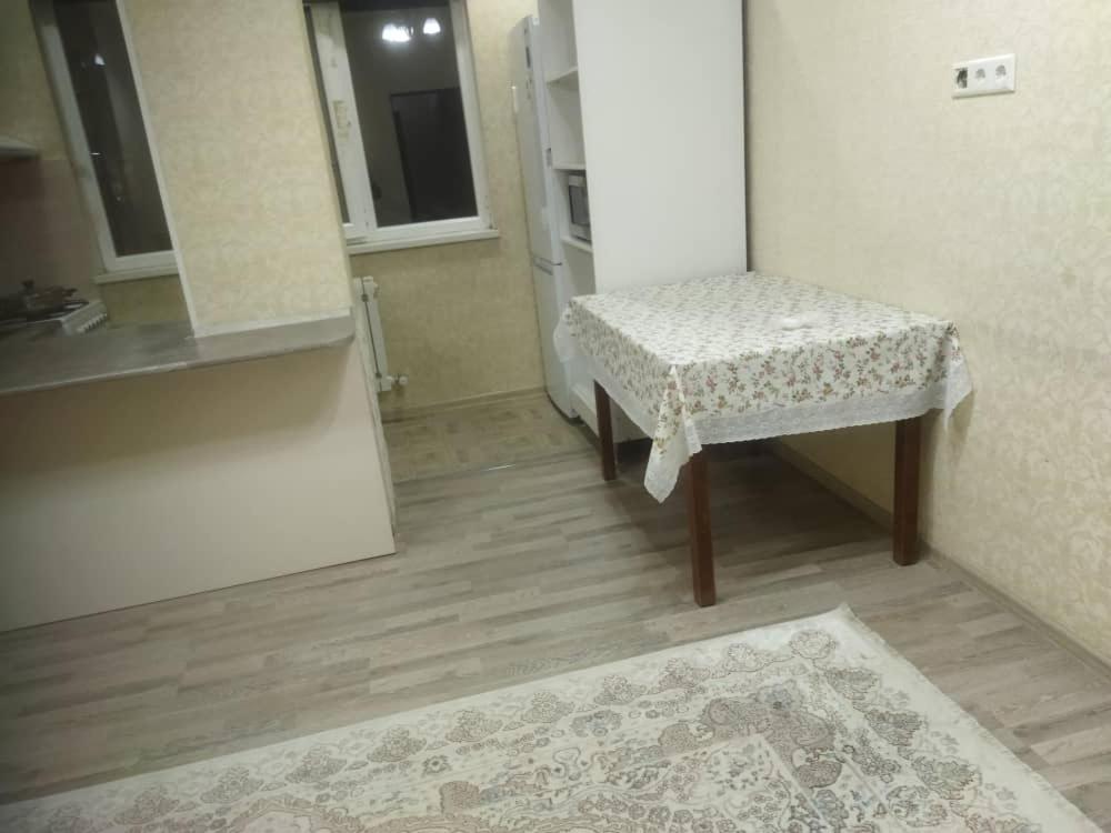 Habitación con mesa, taburete y alfombra en apart NUR, en Bishkek