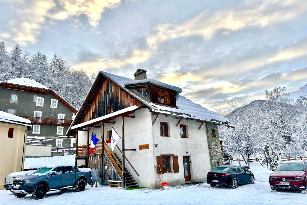 ein schneebedecktes Haus mit davor geparkt in der Unterkunft CASA-Le Gerland pretty duplex in a chalet St-Véran 7p in Saint-Véran