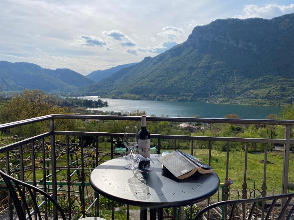 a table with a bottle of wine and glasses on a balcony at Casa Carla, bis 4 Personen, Garten, Balkon mit Blick auf den See und die Berge in Crone