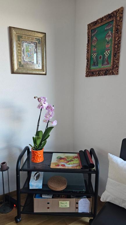 a table with a flower in a vase on it at Appartement meublé à louer à Nax in Nax