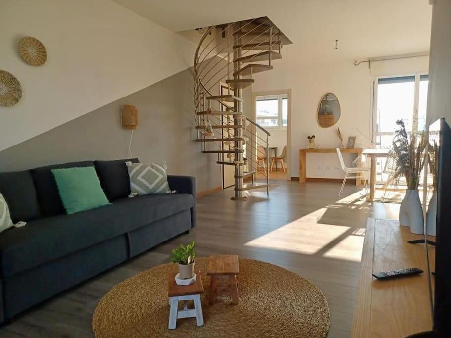 a living room with a blue couch and a spiral staircase at Sui Generis penthouse with terraces in Milan