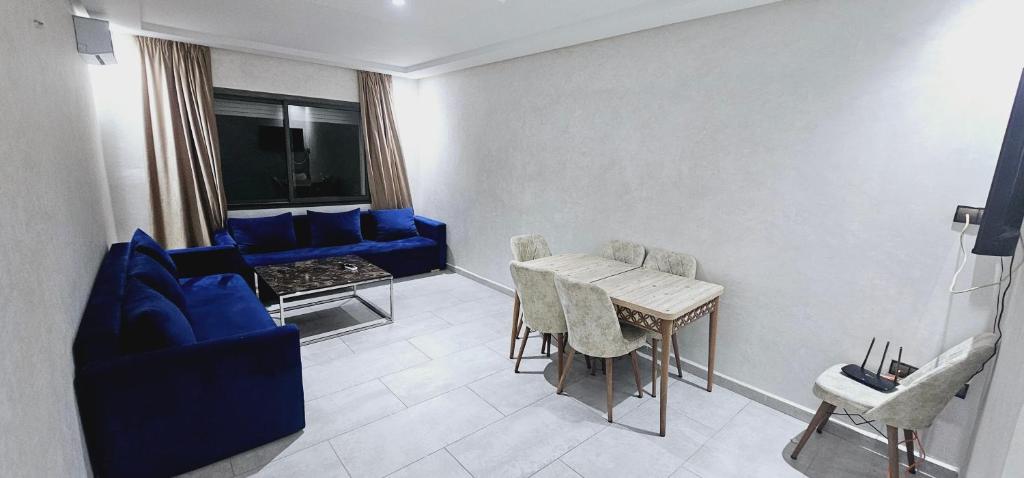 - un salon avec une table et un canapé bleu dans l'établissement Apartment Tangier City Cornice, à Tanger
