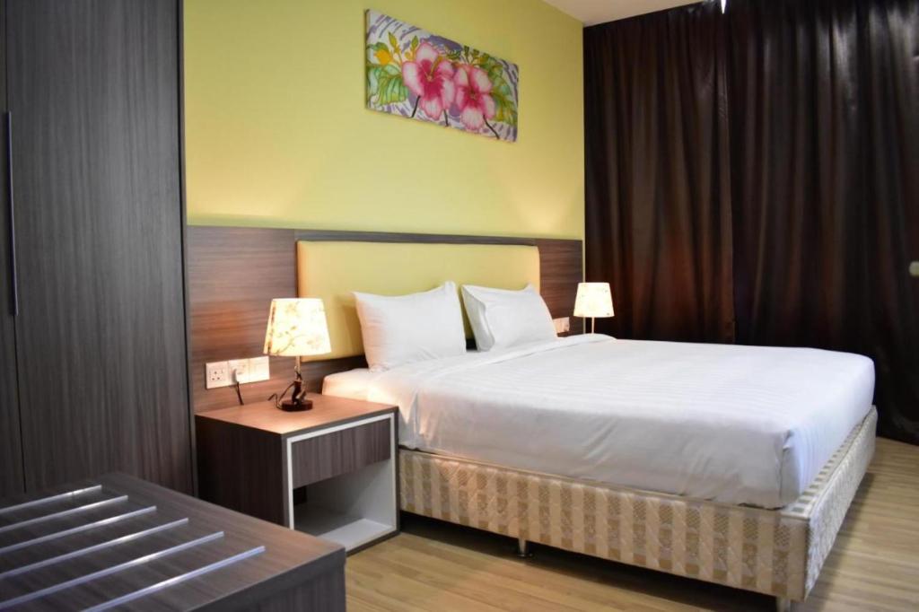 Habitación de hotel con cama y mesa con lámpara en MetraSquare 308 Easy Suite, en Melaka