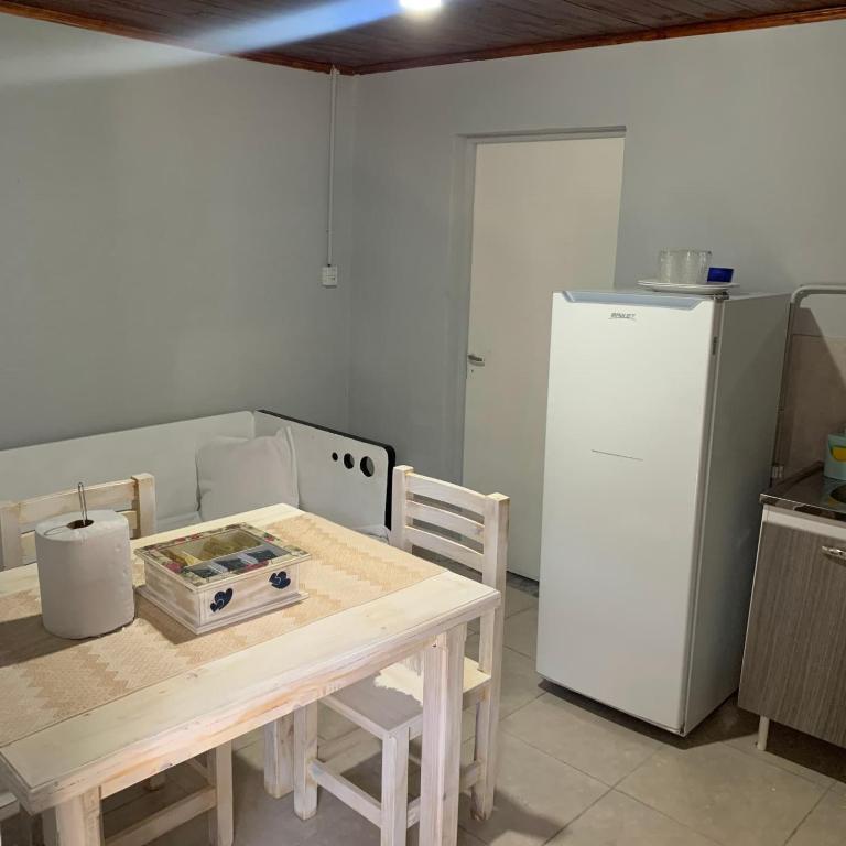 uma cozinha com uma mesa e um frigorífico branco em Departamento Temporario amueblado em Corrientes