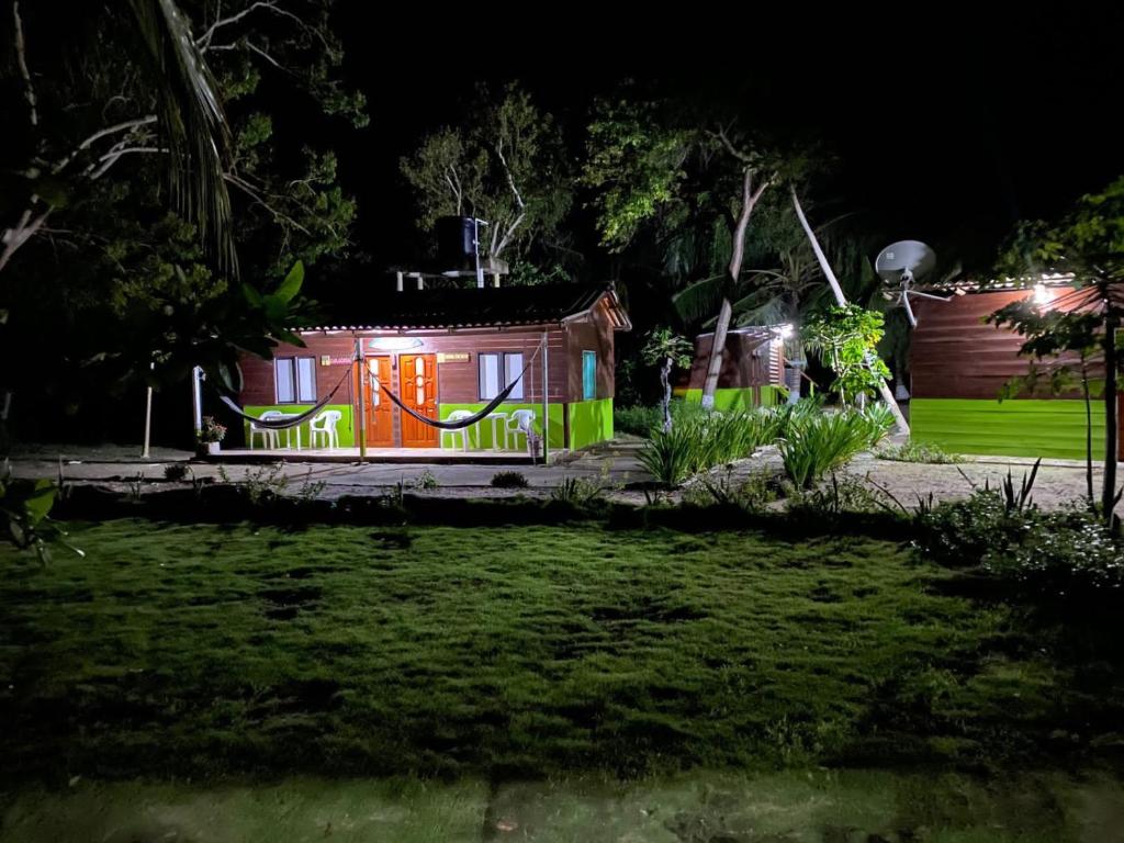 una casa con luces encendidas en un patio por la noche en Eco Hotel Bosque Encantado, en Isla Grande