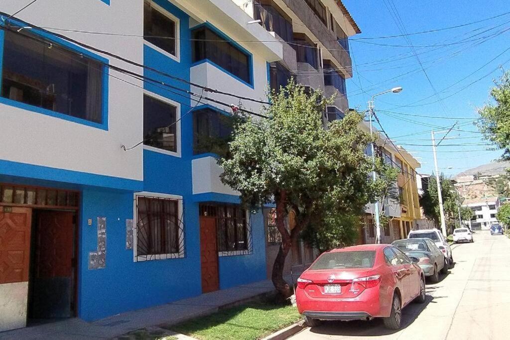 a red car parked next to a blue and white building at Kaypi Samay in Cusco