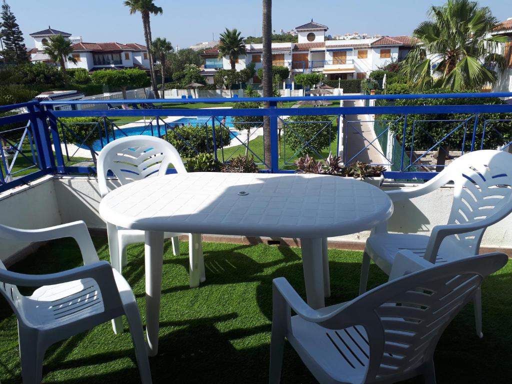 een witte tafel en stoelen op een balkon met een zwembad bij Apartamento Playa Vera in Vera