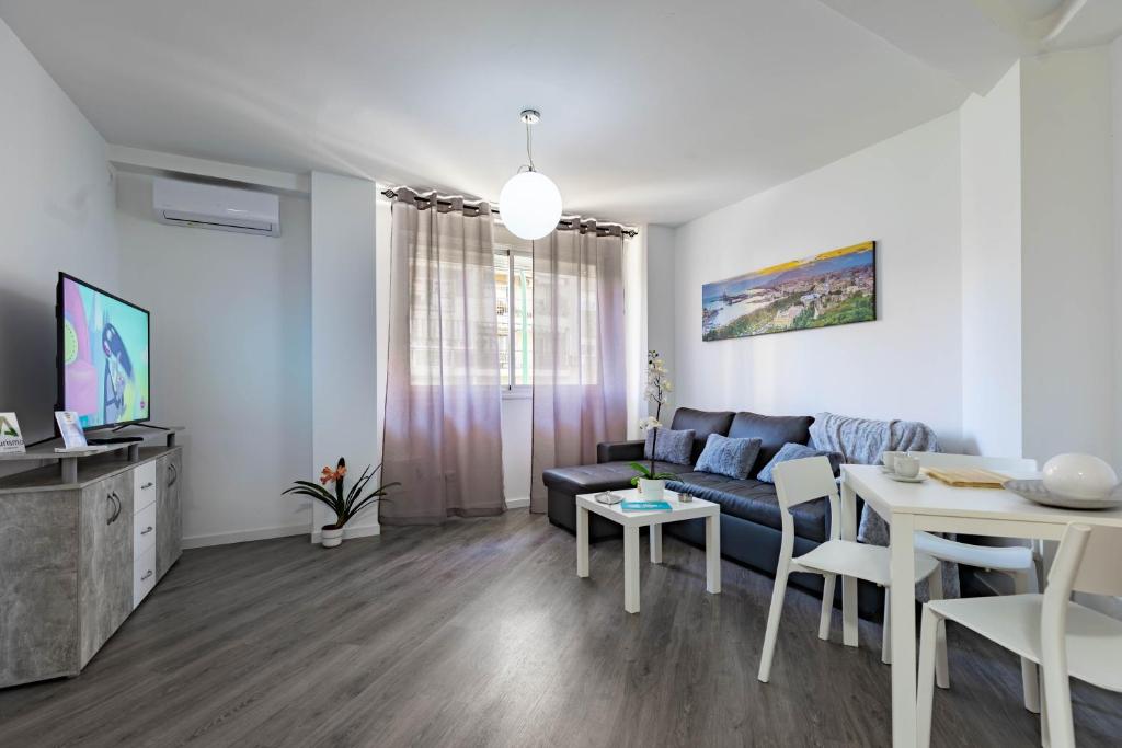 een woonkamer met een bank en een tafel bij Apartamento Carvajal in Málaga